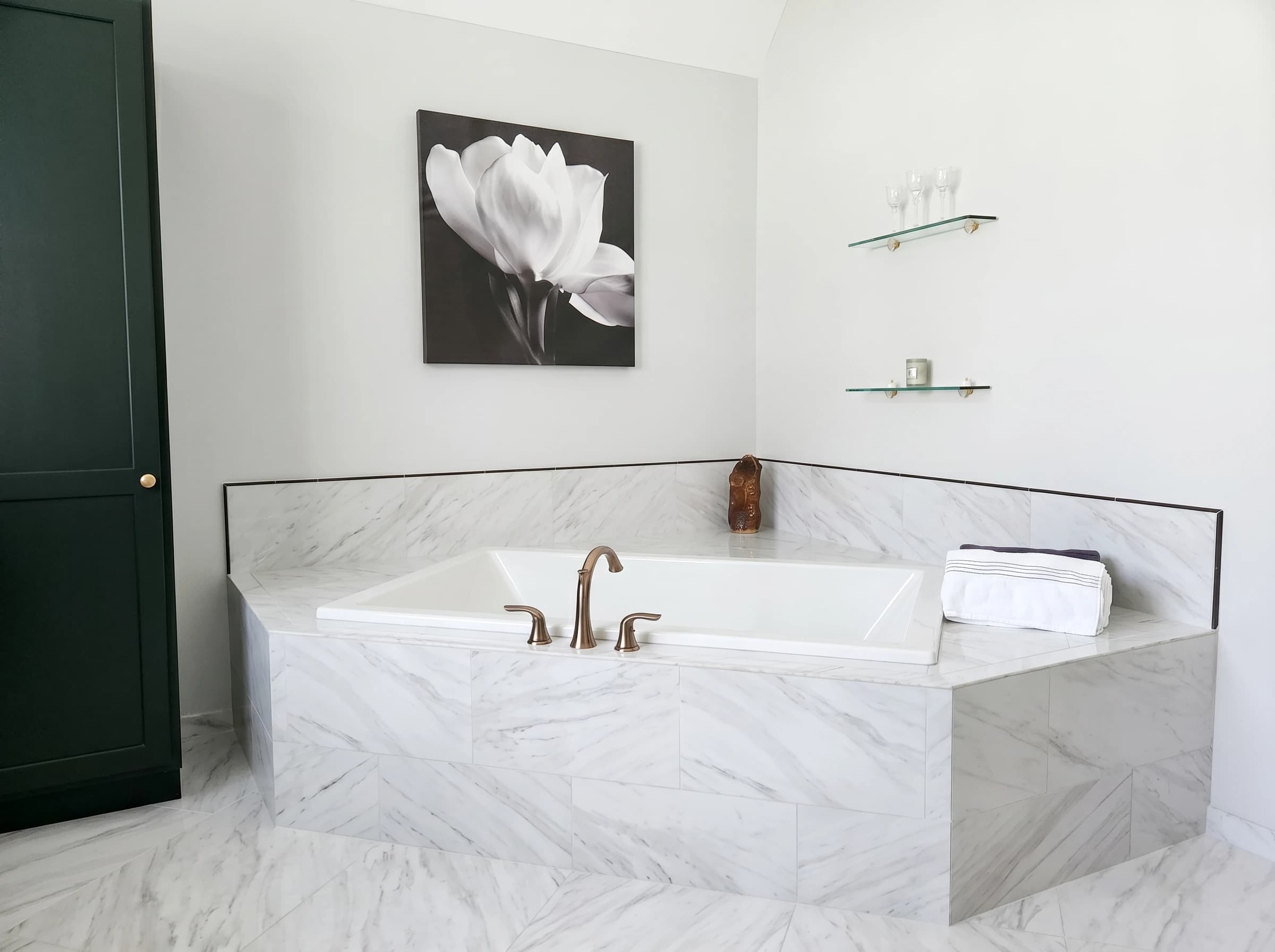 Freestanding bathtub with marble surroundings in a luxury bathroom remodel.