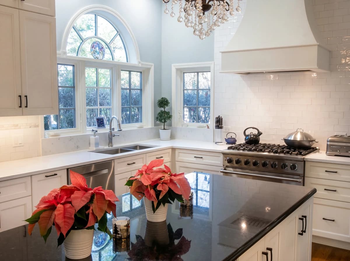 A modern kitchen with white cabinets, stainless steel appliances, and marble countertops.