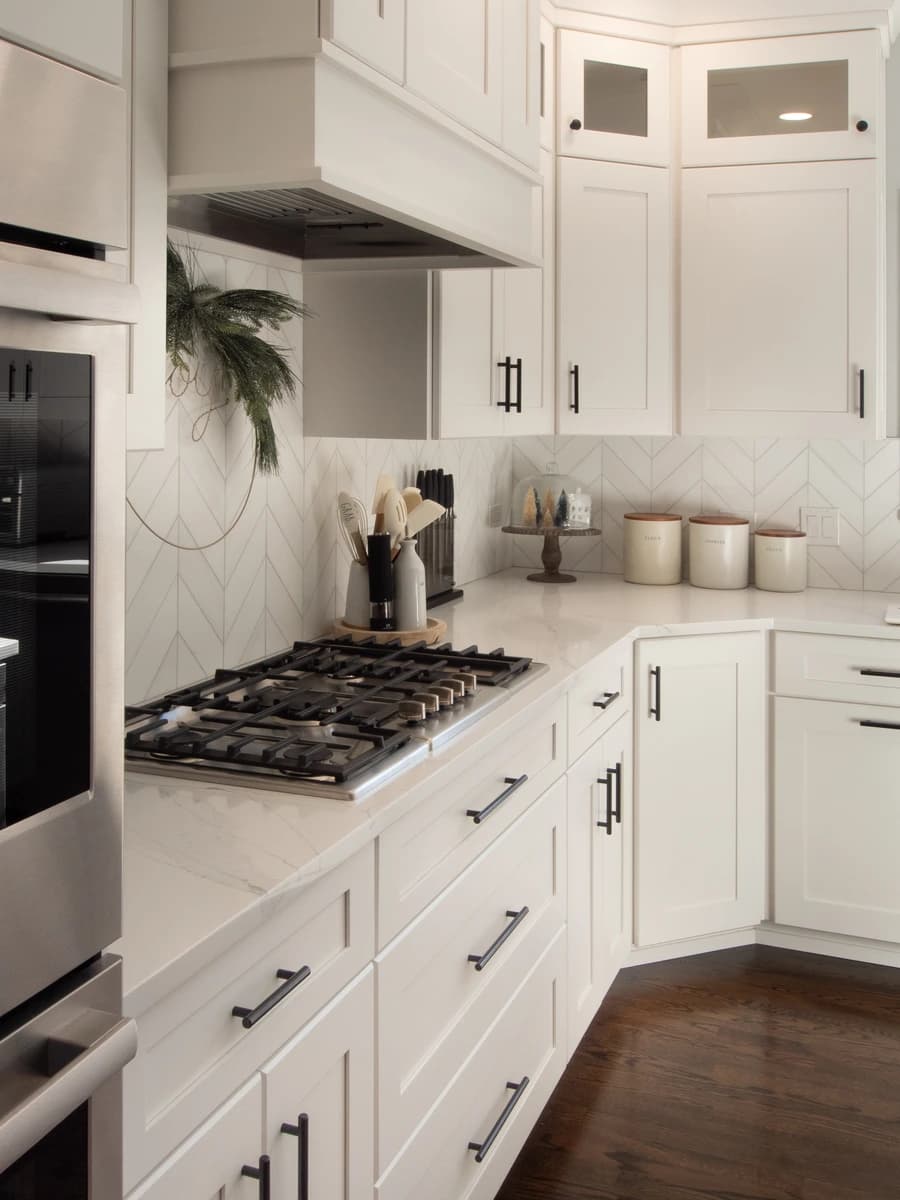 Kitchen with white cabinets and marble countertops.