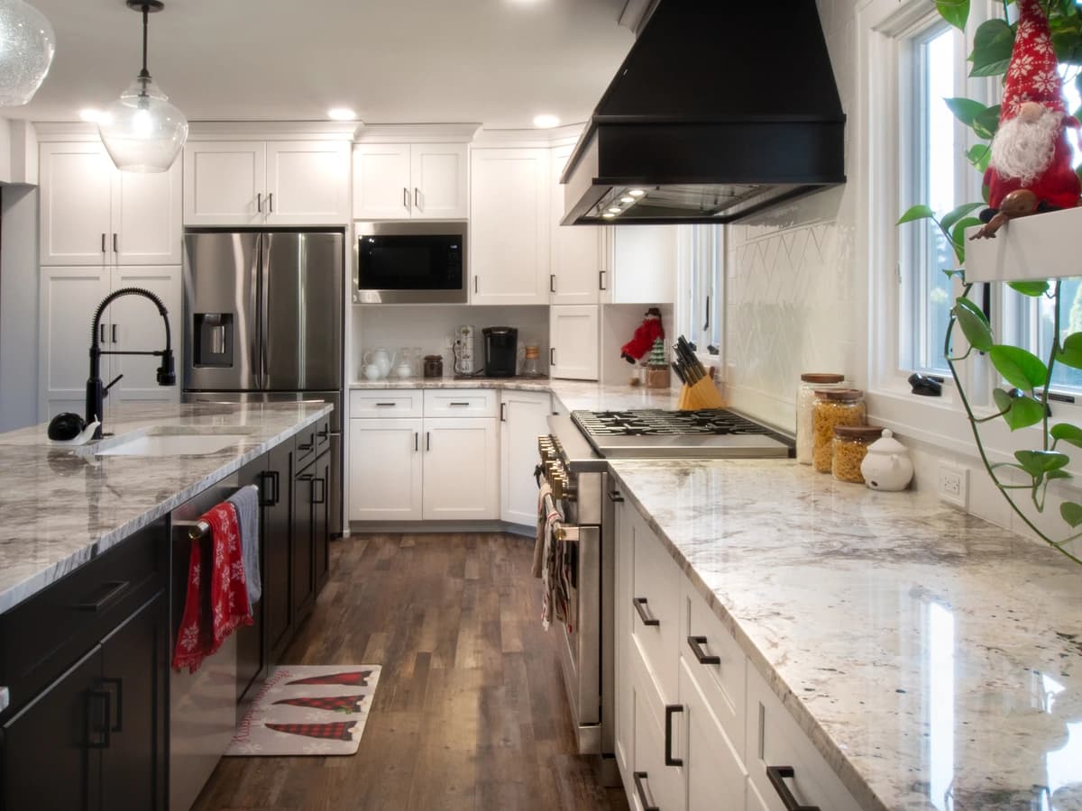 Modern kitchen with granite countertops, black cabinetry, stainless steel appliances.