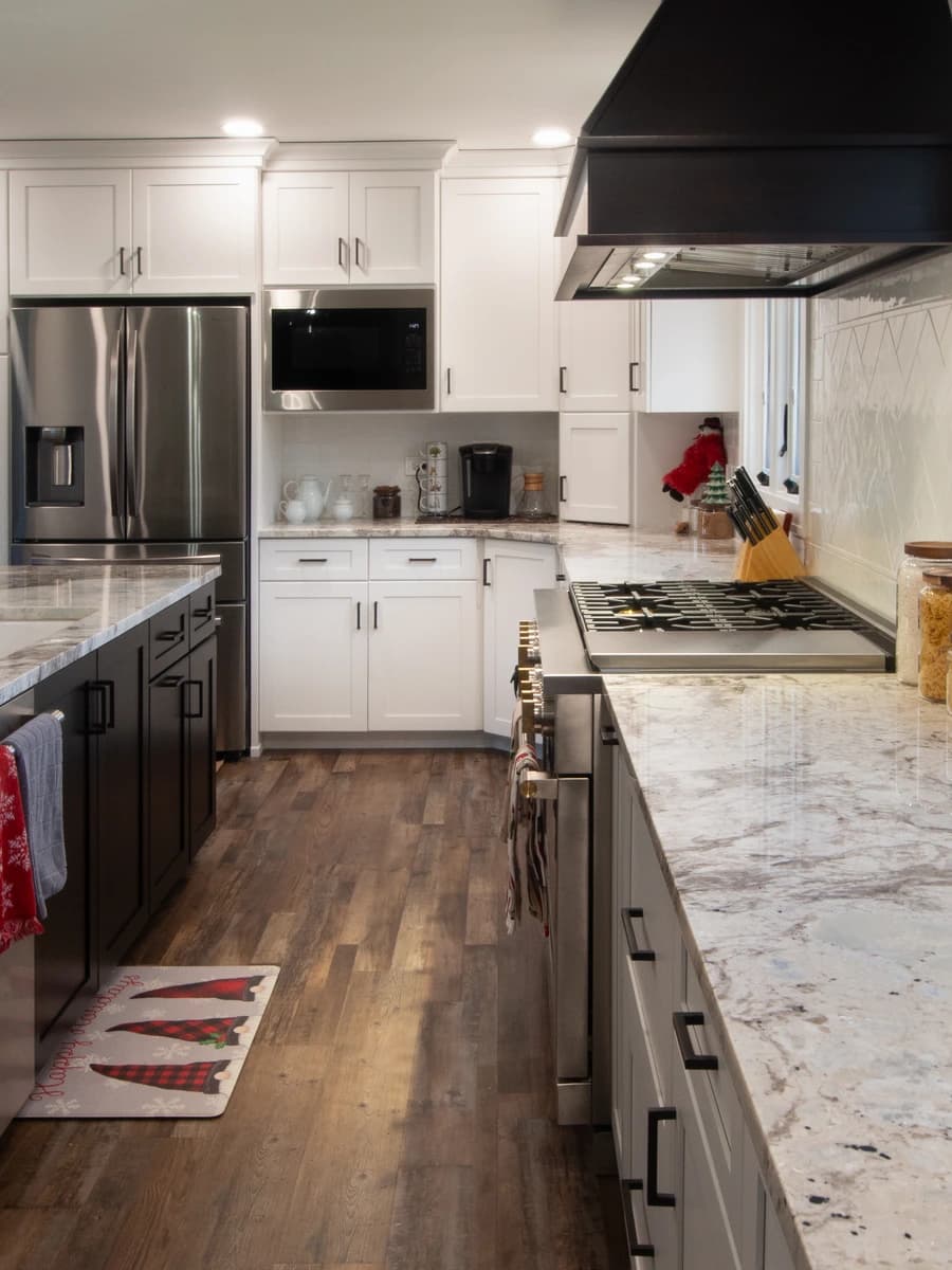 Large, modern kitchen with white cabinets, granite countertops, and stainless steel appliances.