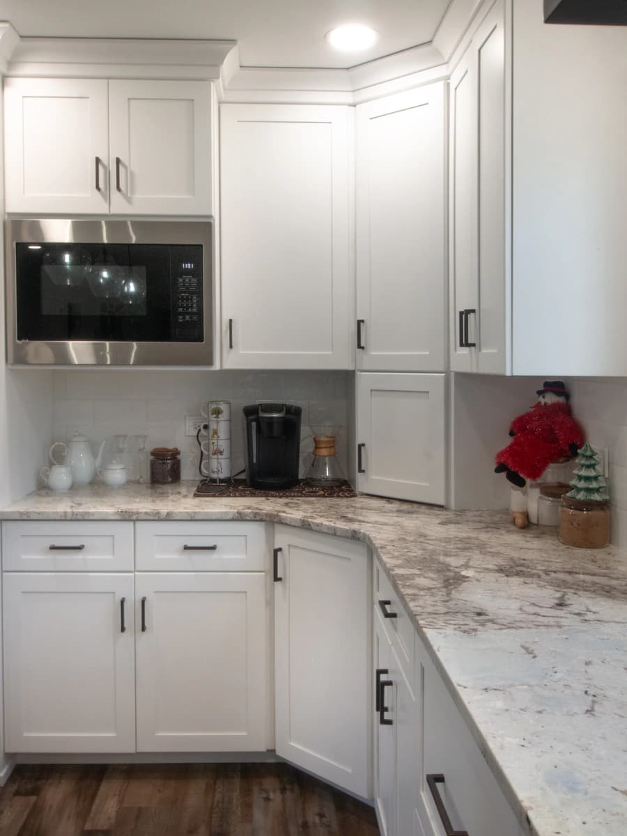 Modern kitchen with white cabinets, granite countertops, and stainless steel appliances.