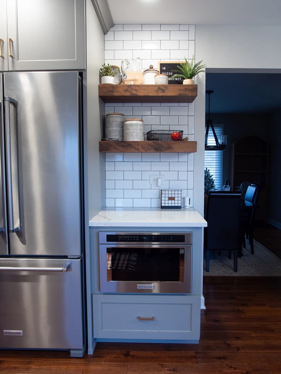 Modern kitchen with white brick backsplash, stainless steel appliances, and industrial style metal