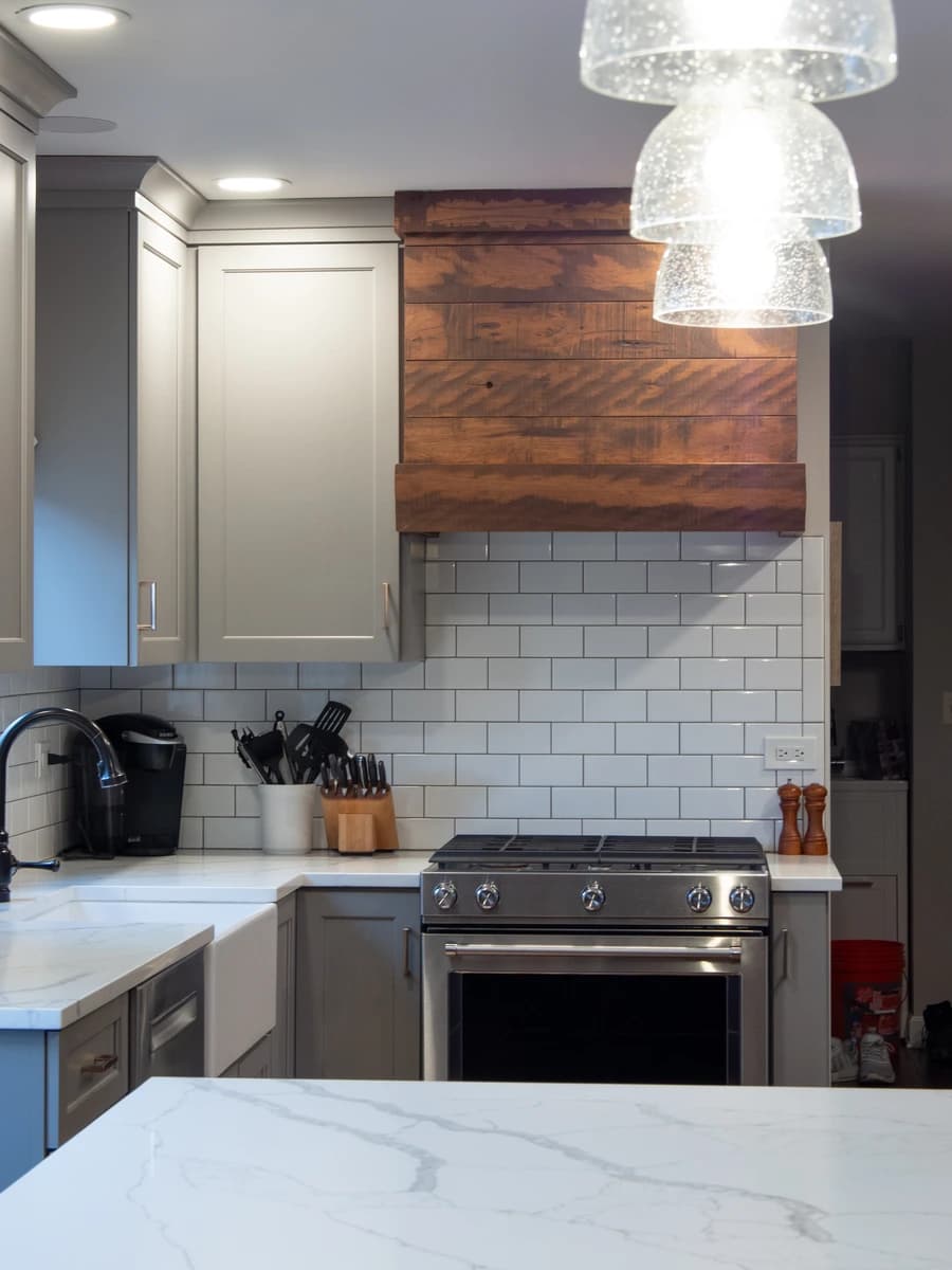 Modern kitchen with wooden cabinets, white marble countertops, and a double oven.
