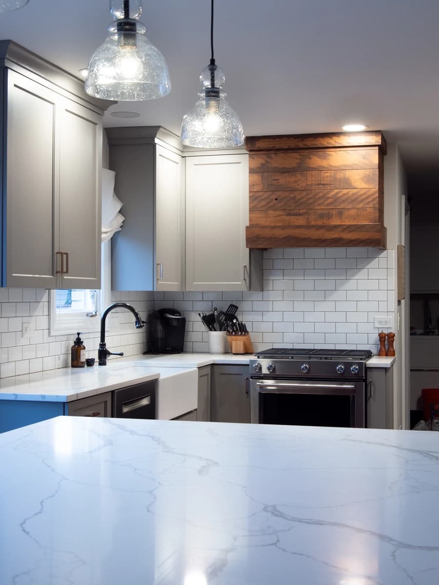 Modern kitchen with marble countertops and a wood kitchen island.