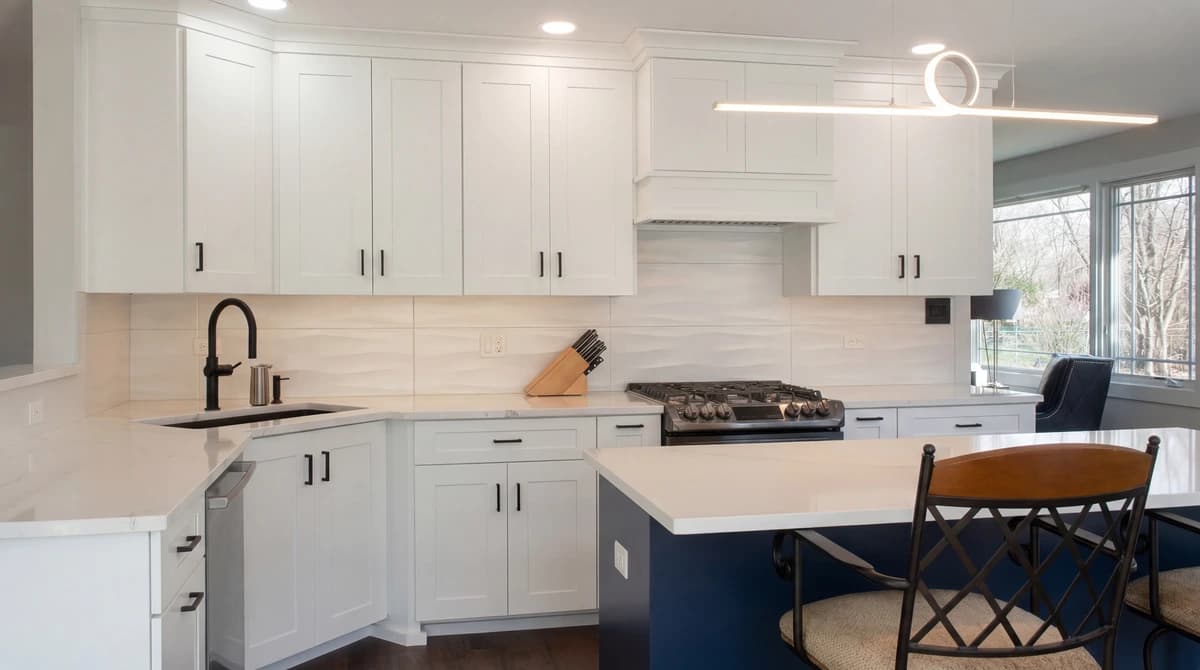 A modern kitchen with white cabinets, a center island, and stainless steel appliances.