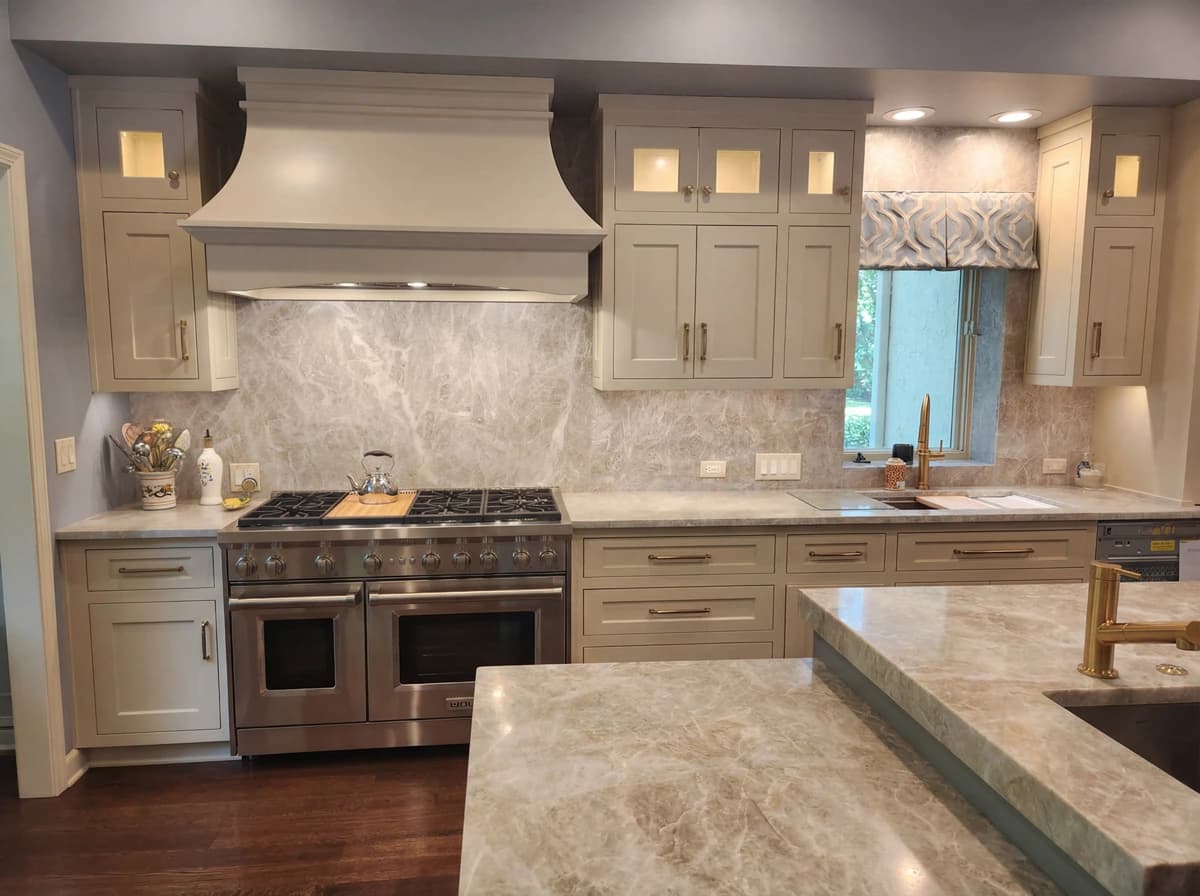 Modern kitchen with light wood cabinets, granite countertops, and stainless steel appliances.