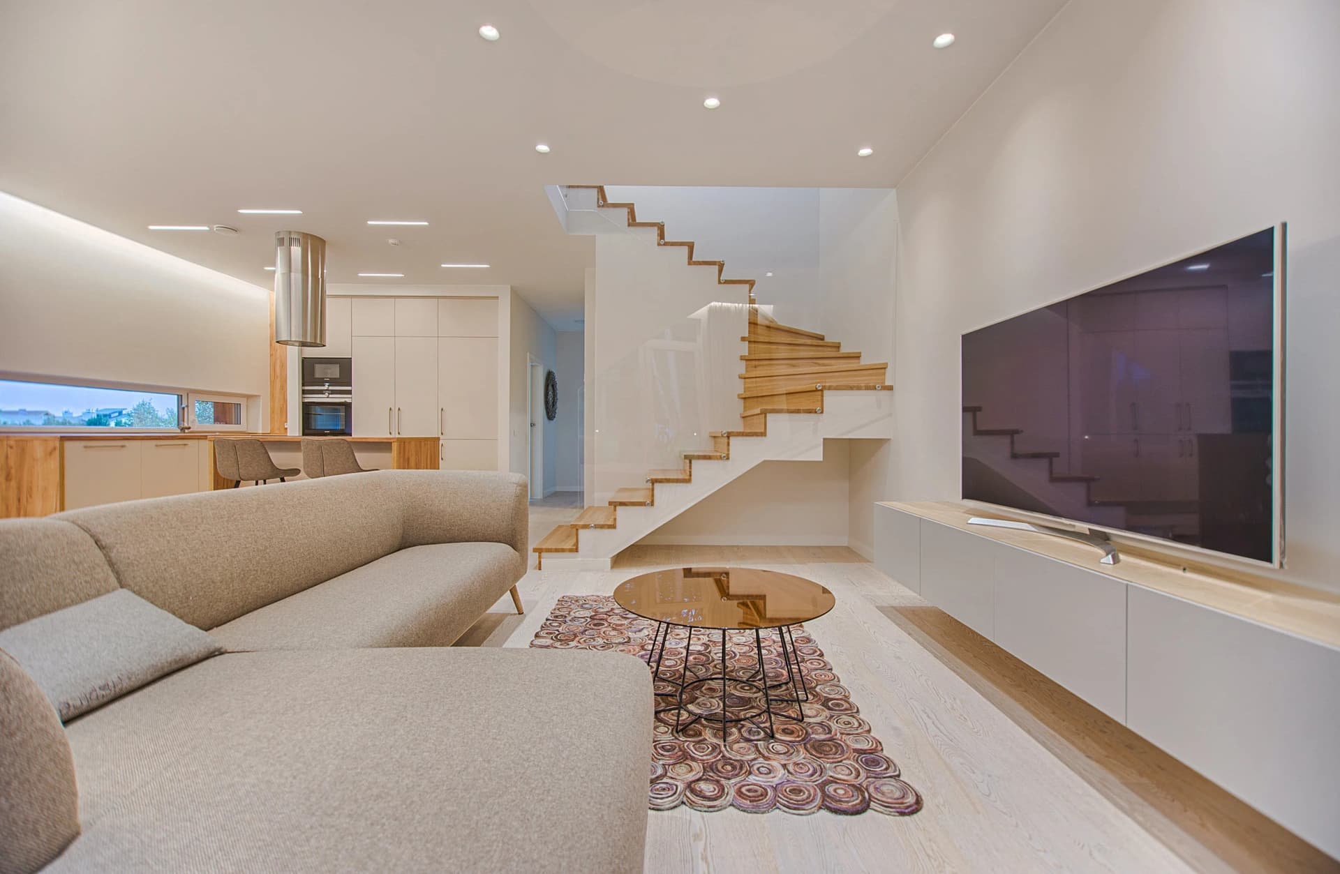 Modern living room with contemporary staircase and minimalist decor.