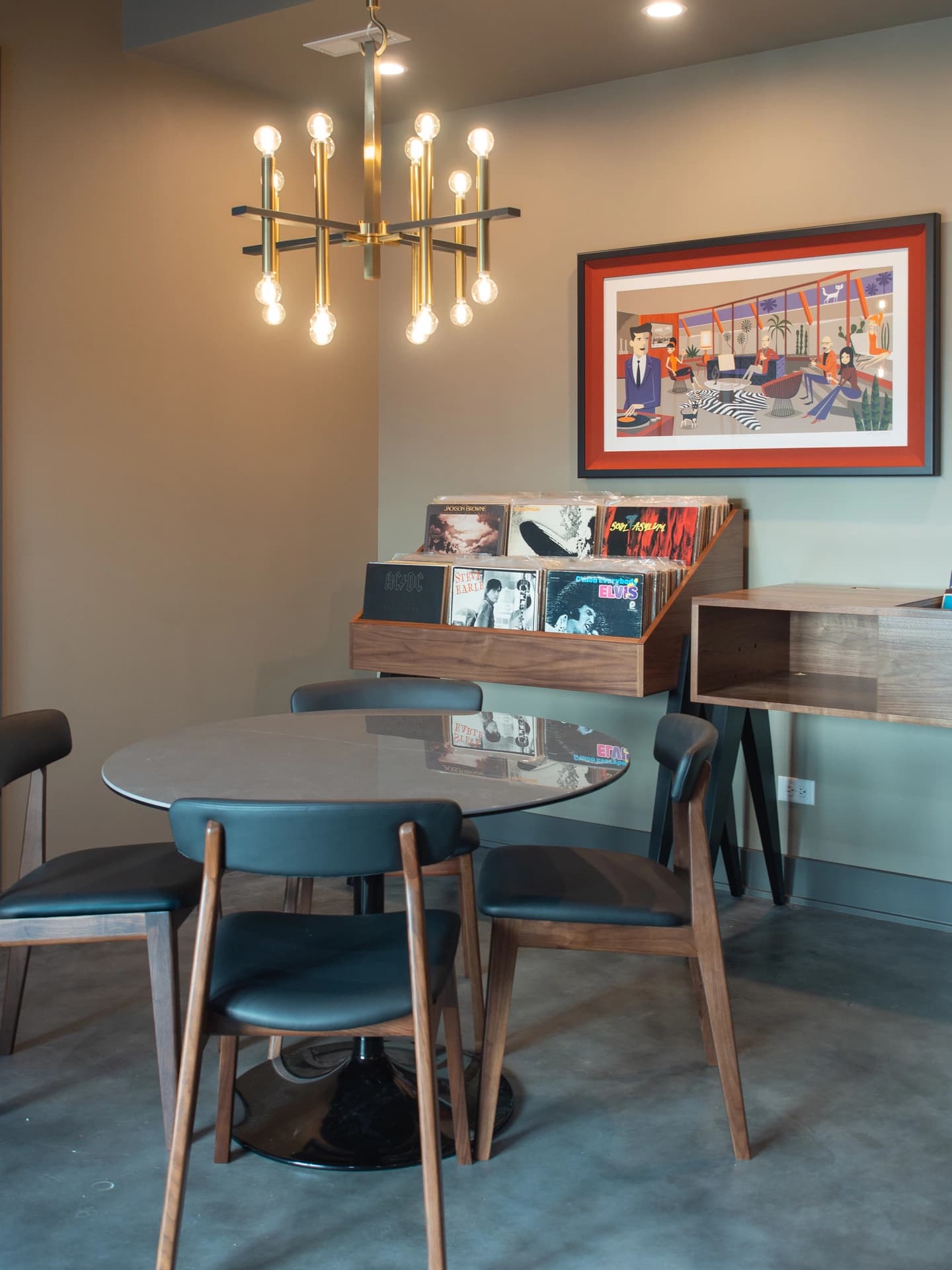 "Modern dining room with table and chairs, contemporary chandelier, and abstract wall art."