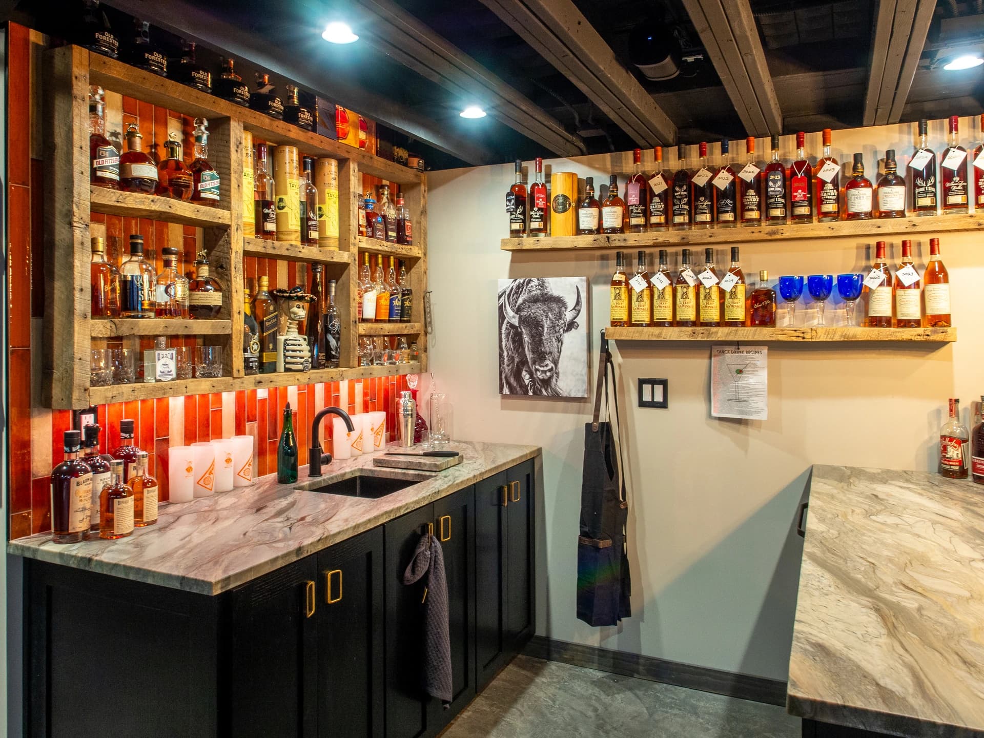 Bar with brown bottles on shelves, black and white sign, and a red and blue striped awning.