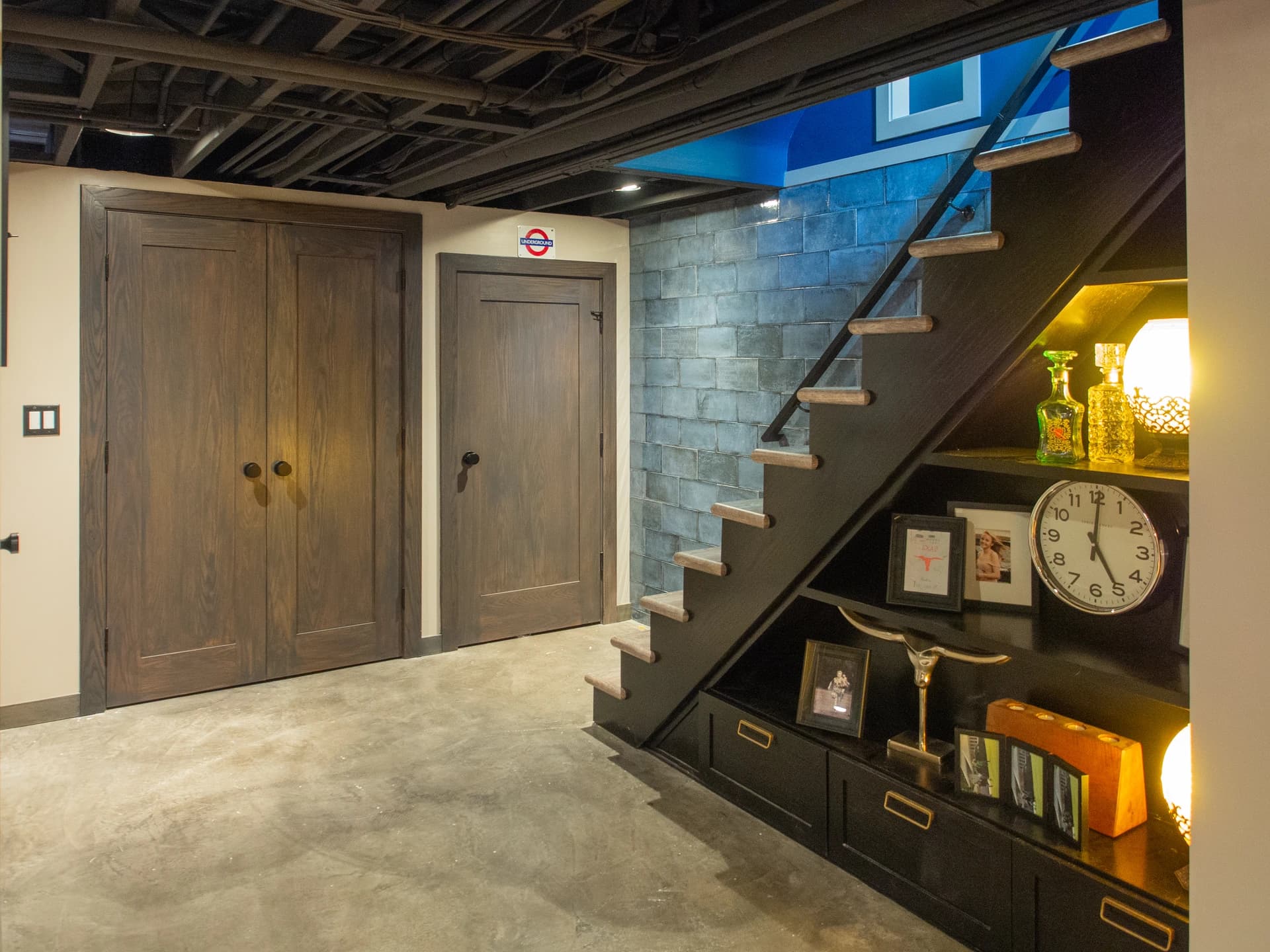 Black staircase leading to a modern kitchen in a renovated basement.
