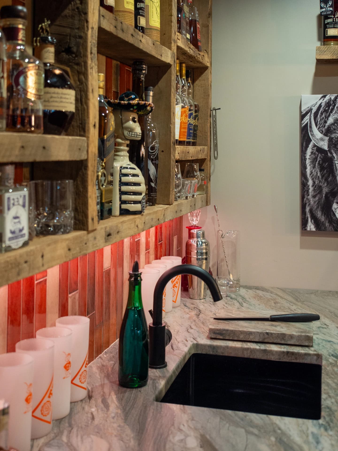 Large wooden wall shelves display an array of bottles.