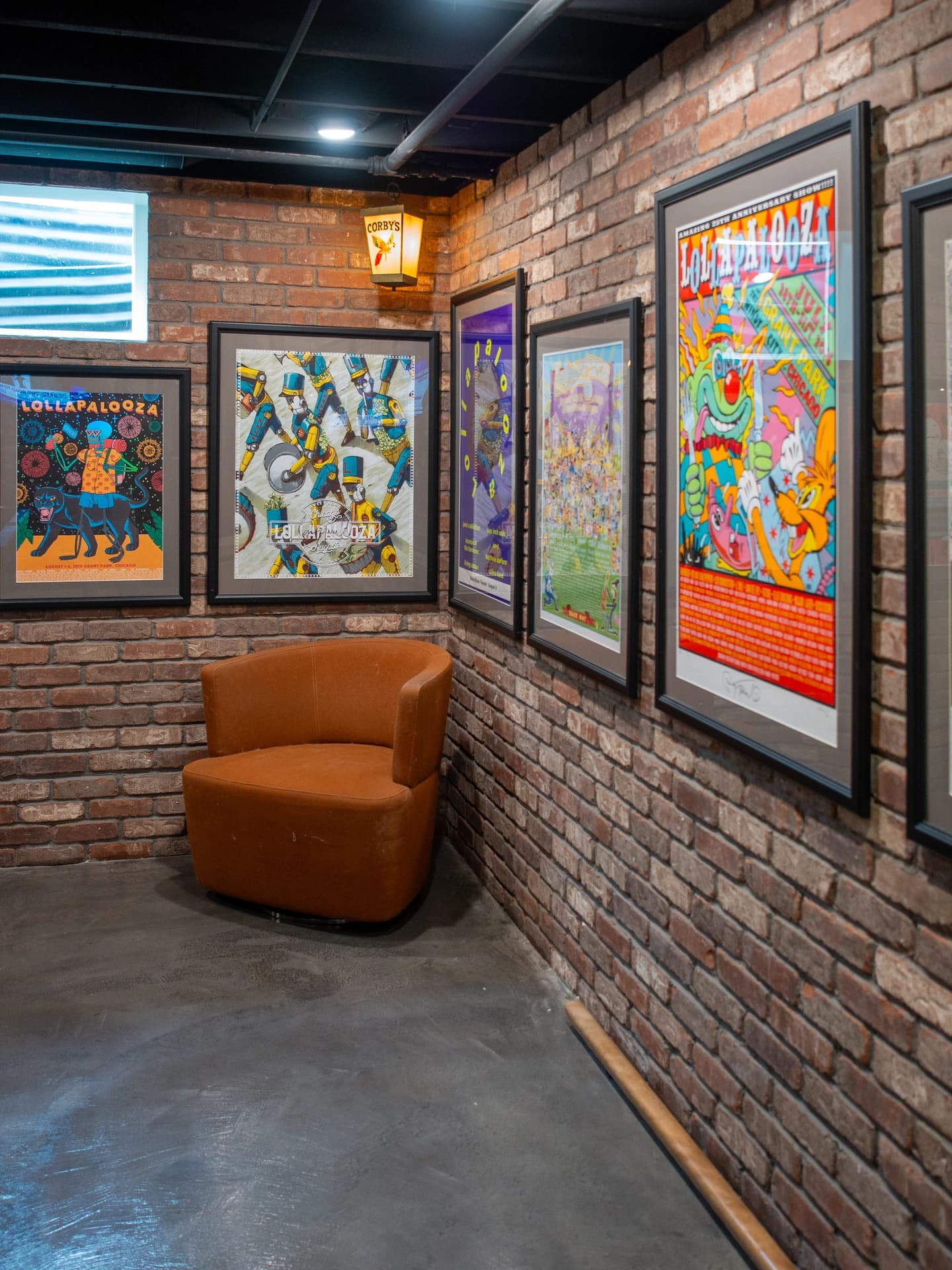 A brick wall adorned with vibrant framed art pieces.