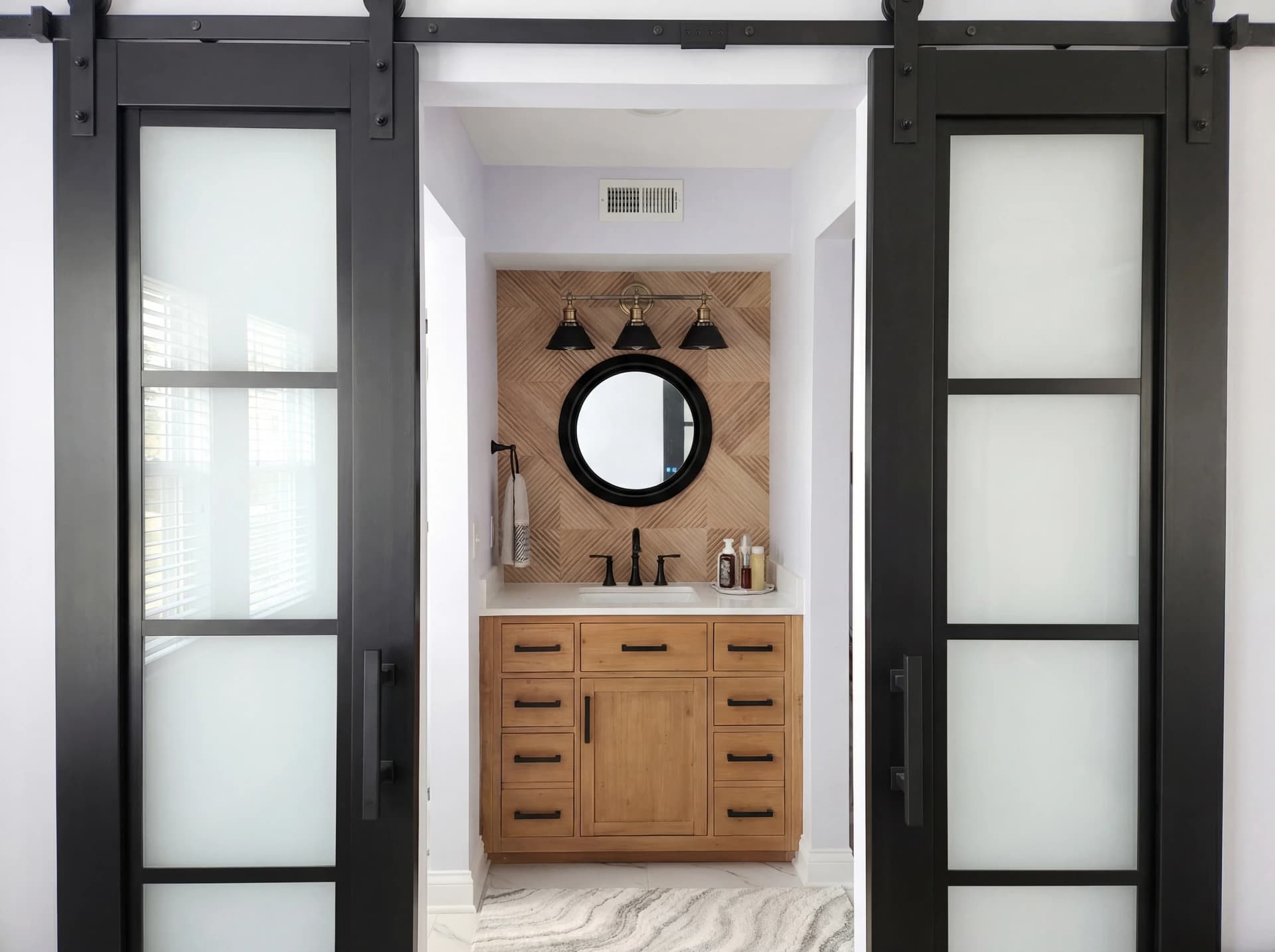Contemporary bathroom with black metal shower enclosures and white and purple tiles.