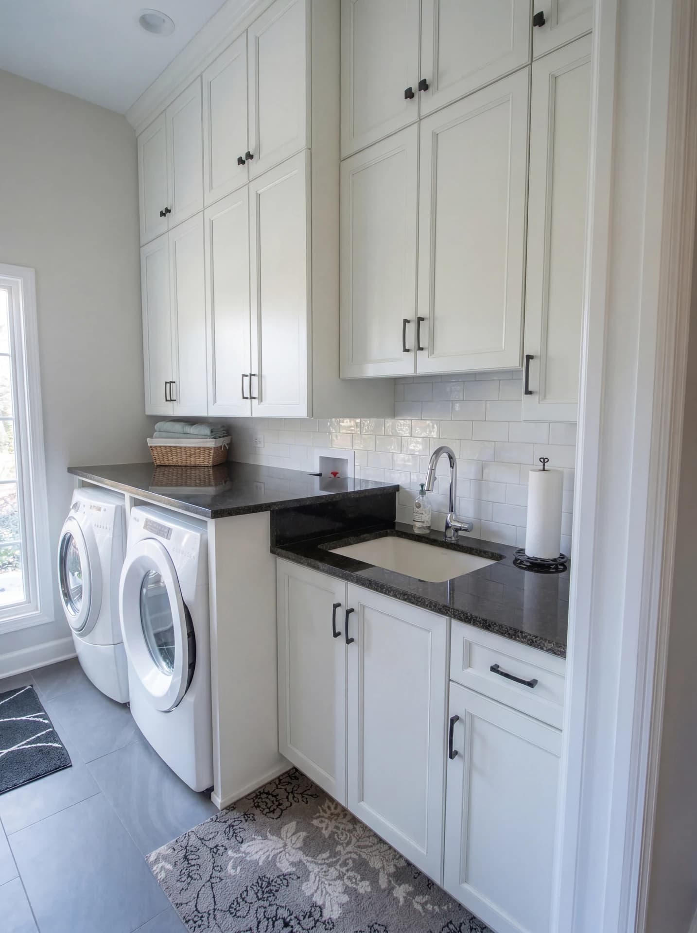 Kitchen with white cabinets, black appliances, and white walls.