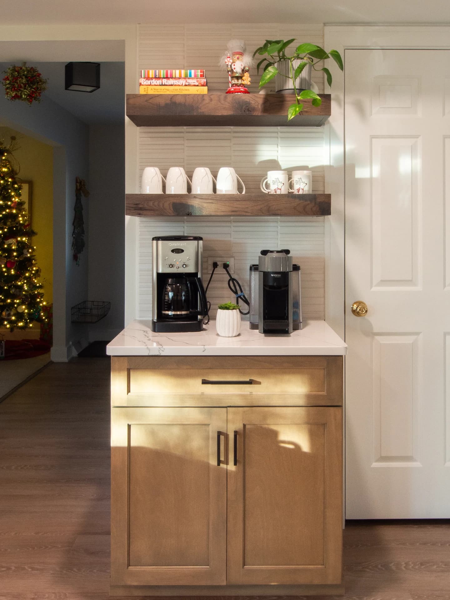 Modern kitchen island with a sleek countertop, shelves above with coffee machine and accessories.