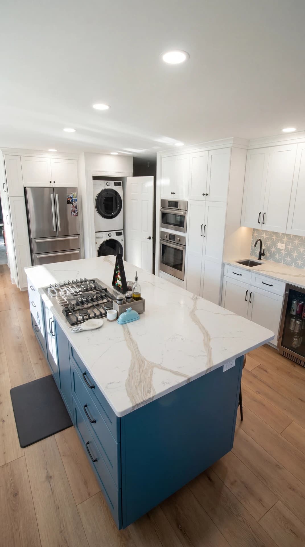 Kitchen with a modern island, blue cabinets, and white appliances.