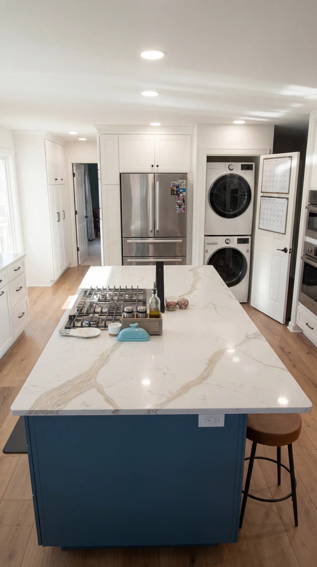 Large kitchen with granite counters, white cabinets, stainless steel appliances, and hardwood floor.