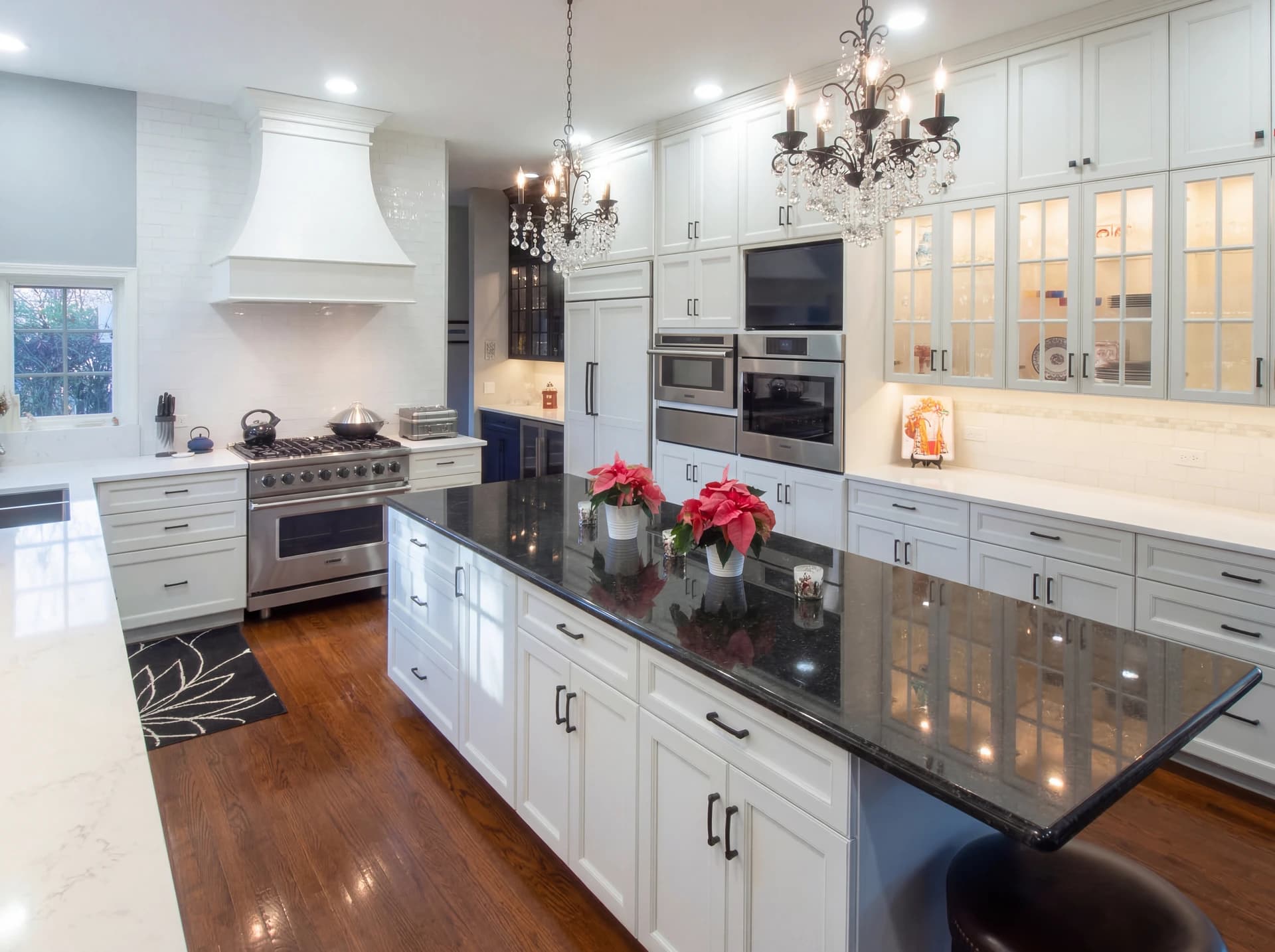 Large, modern kitchen with white cabinets, black countertops, and island.