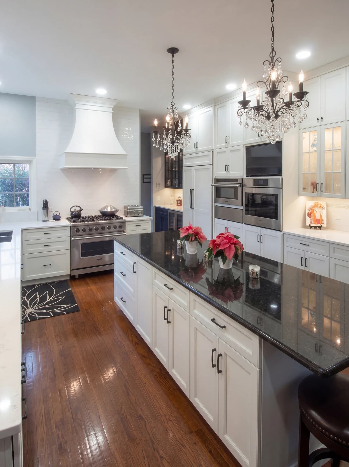 Stylish kitchen with white cabinets, stainless steel appliances, marble countertops, pendant