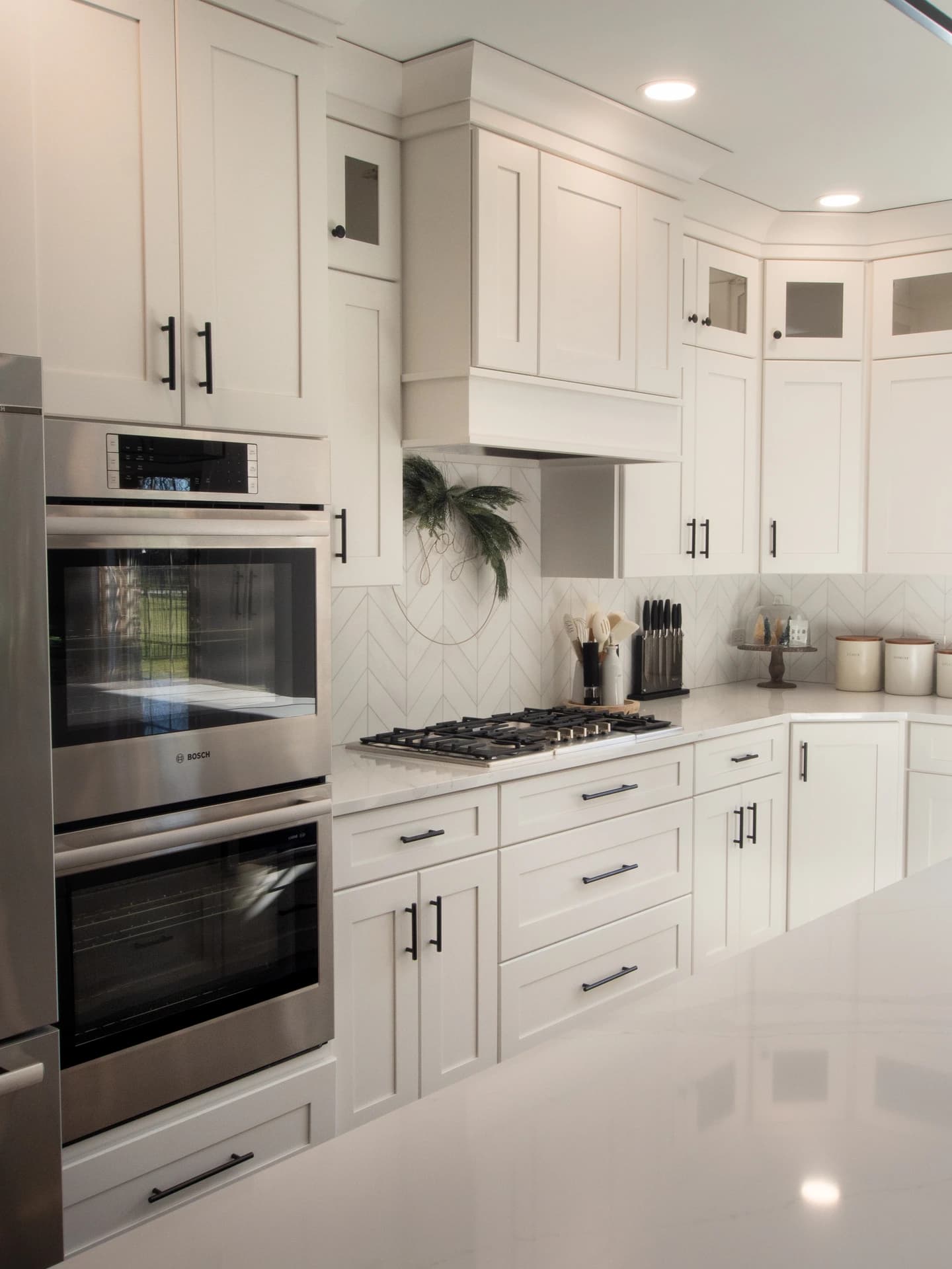 Modern kitchen with white cabinets and stainless steel appliances.
