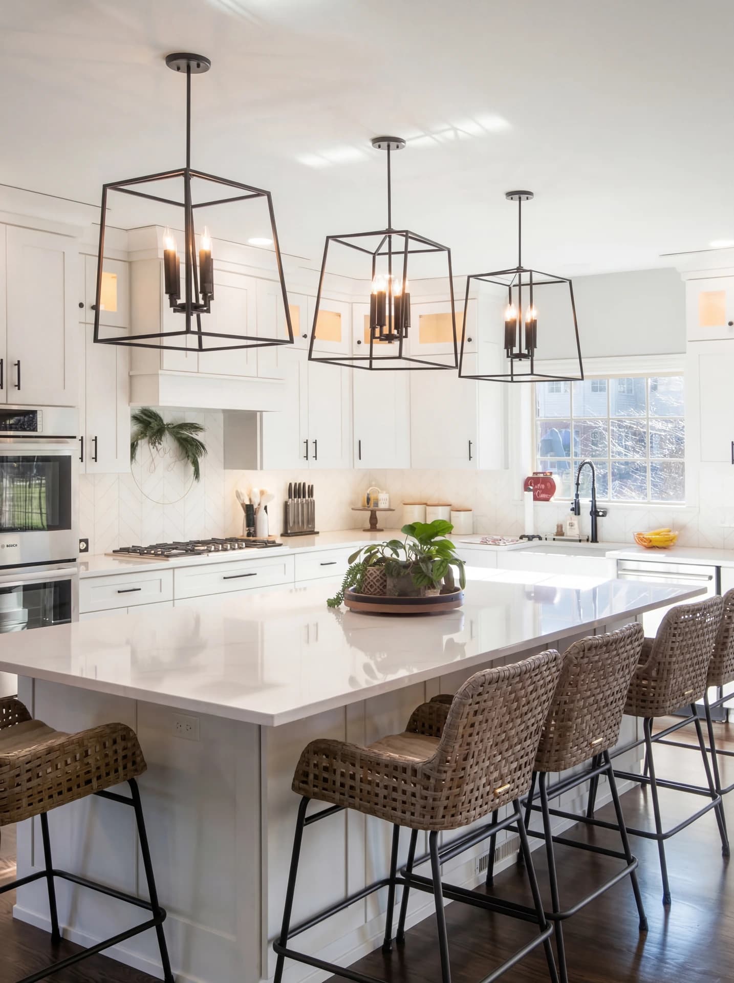 Modern kitchen with white island and black bar stools, hanging pendant lights over island, and