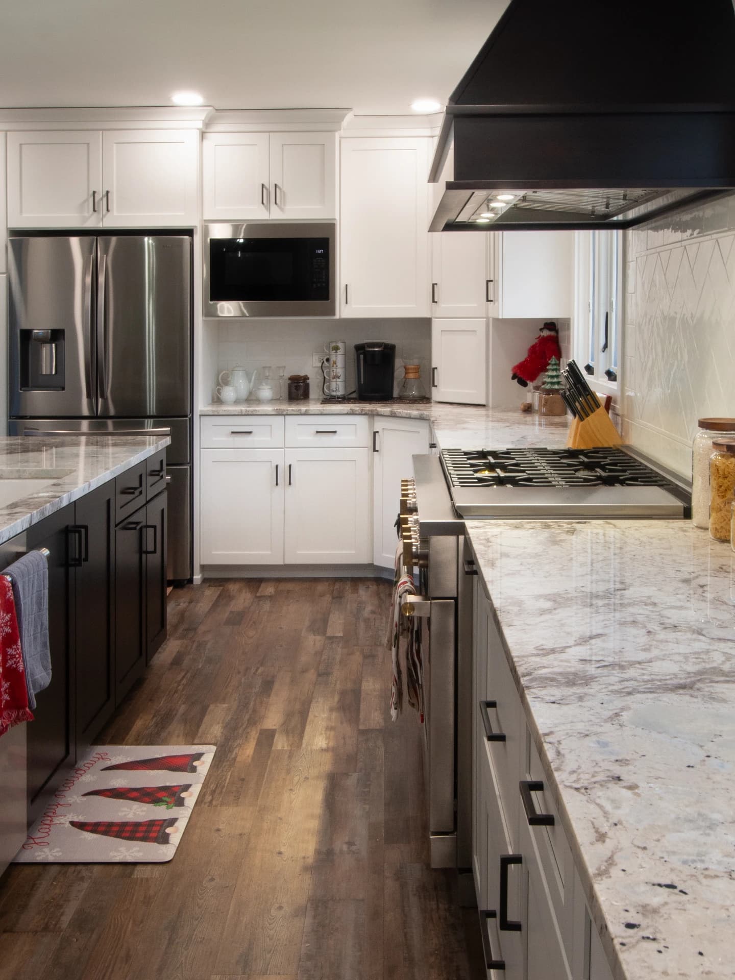 Large, modern kitchen with white cabinets, granite countertops, and stainless steel appliances.