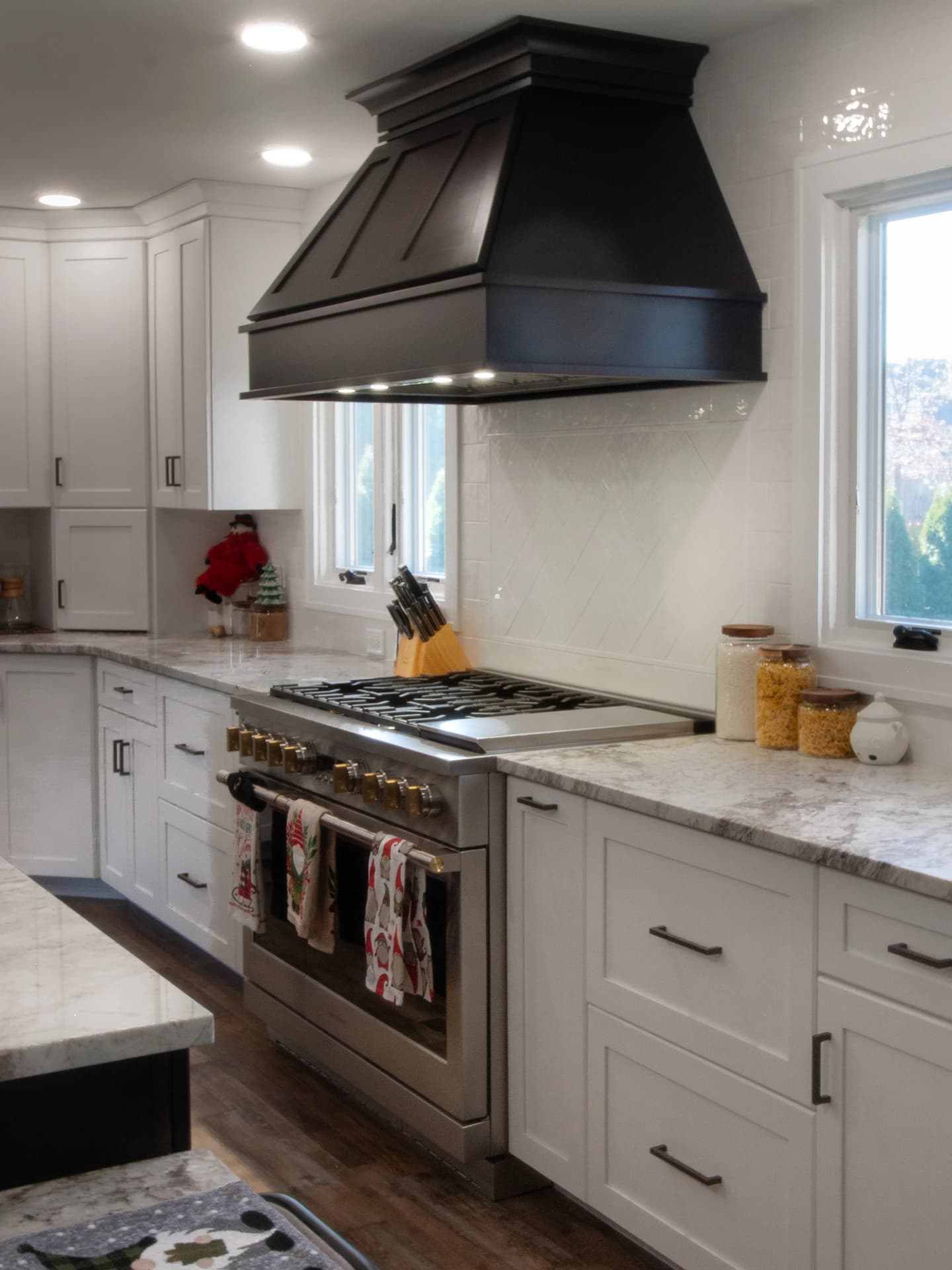 Modern kitchen with dark wood cabinets, white countertops, and stainless steel appliances.