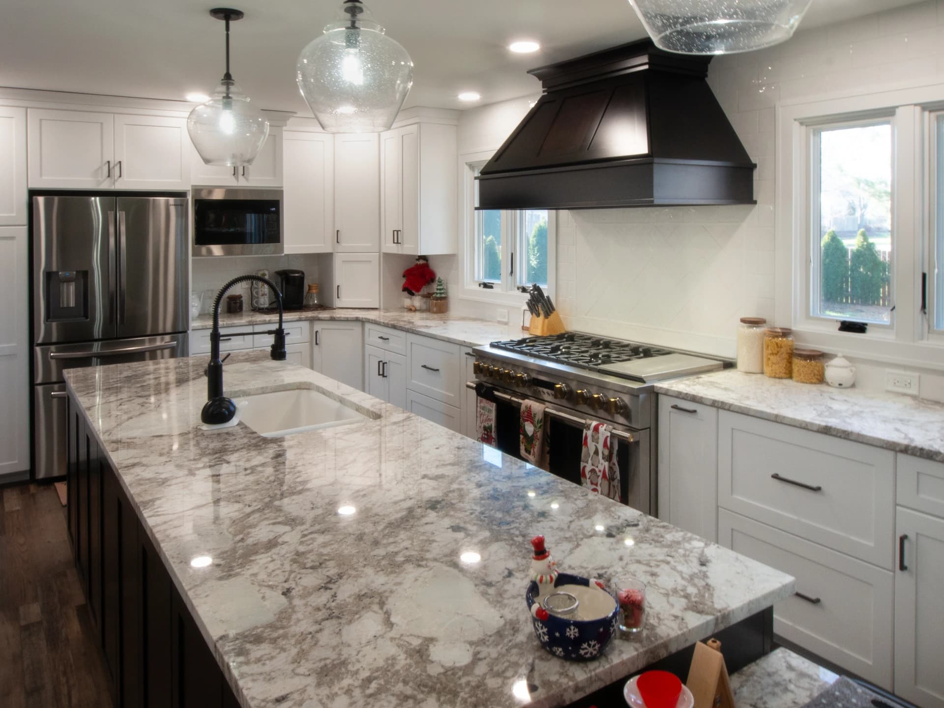 Modern kitchen with marble countertops and stainless steel appliances.