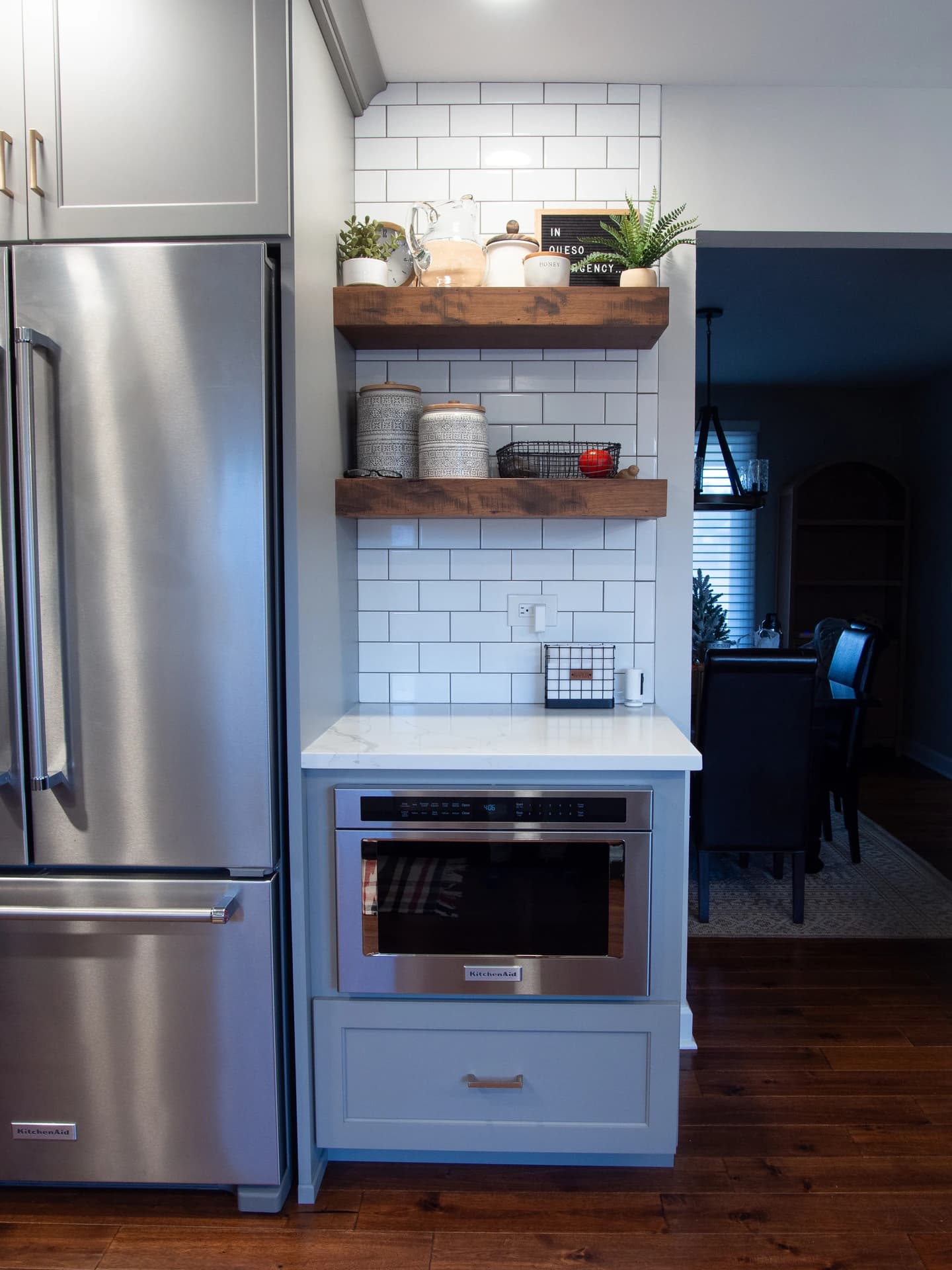 Modern kitchen with white brick backsplash, stainless steel appliances, and industrial style metal