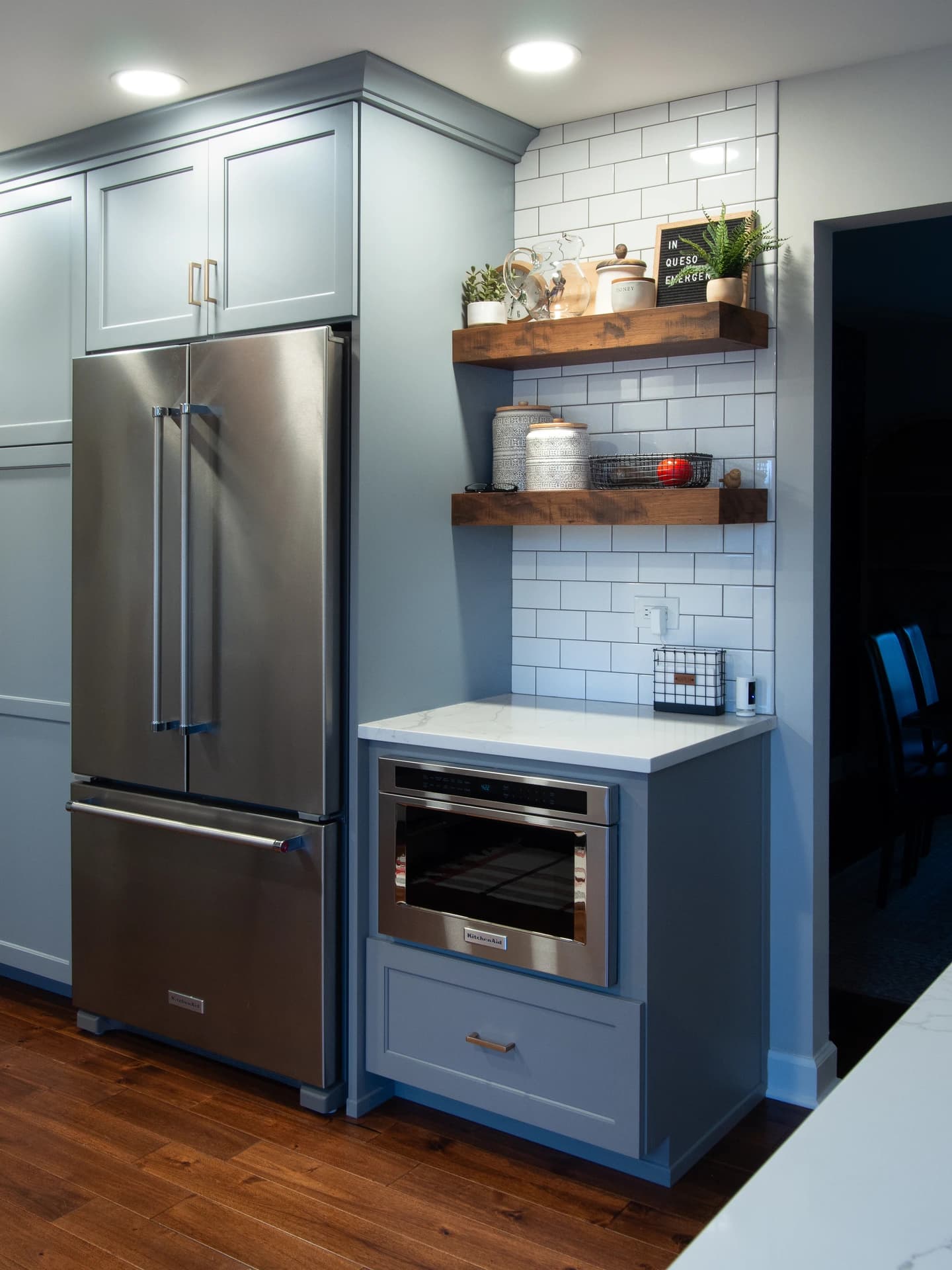 Grey kitchen cabinets and stainless steel appliances.