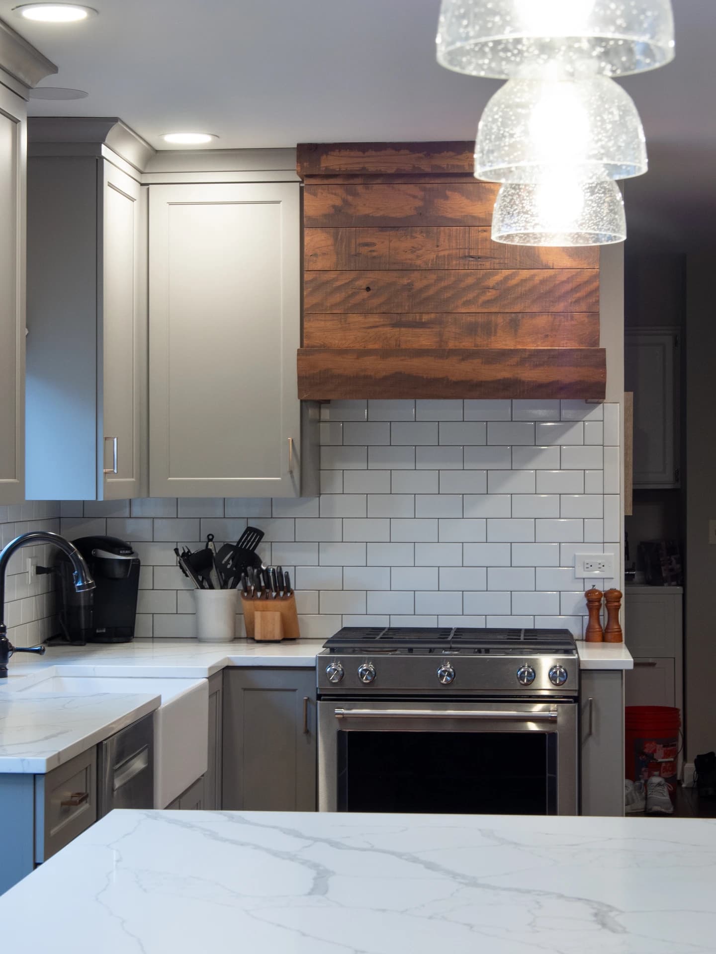 Modern kitchen with wooden cabinets, white marble countertops, and a double oven.