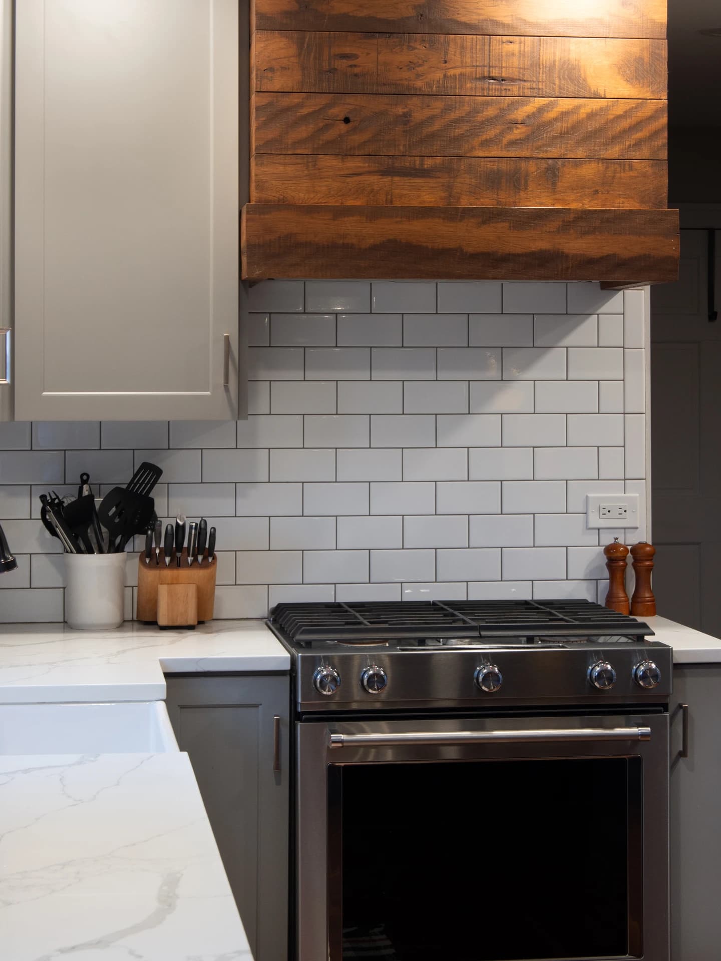 Kitchen remodel with modern stainless steel stove and gray cabinets.