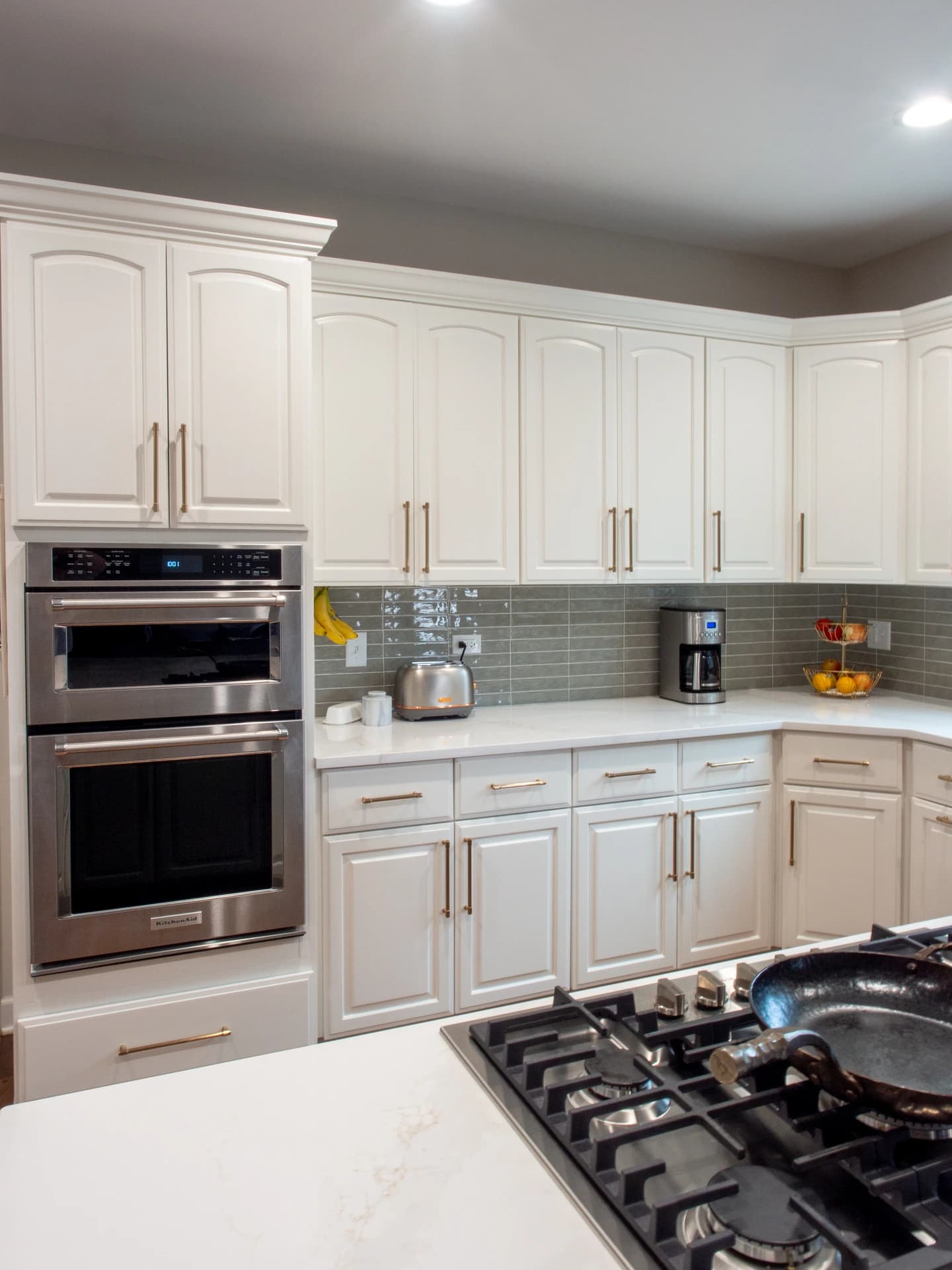 Modern kitchen with white cabinets and stainless steel appliances.