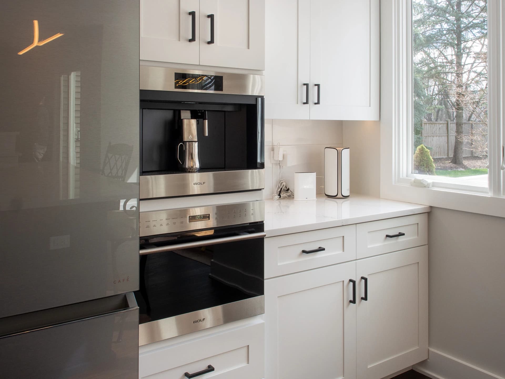 Modern kitchen with stainless steel appliances, white cabinets, and a large island.