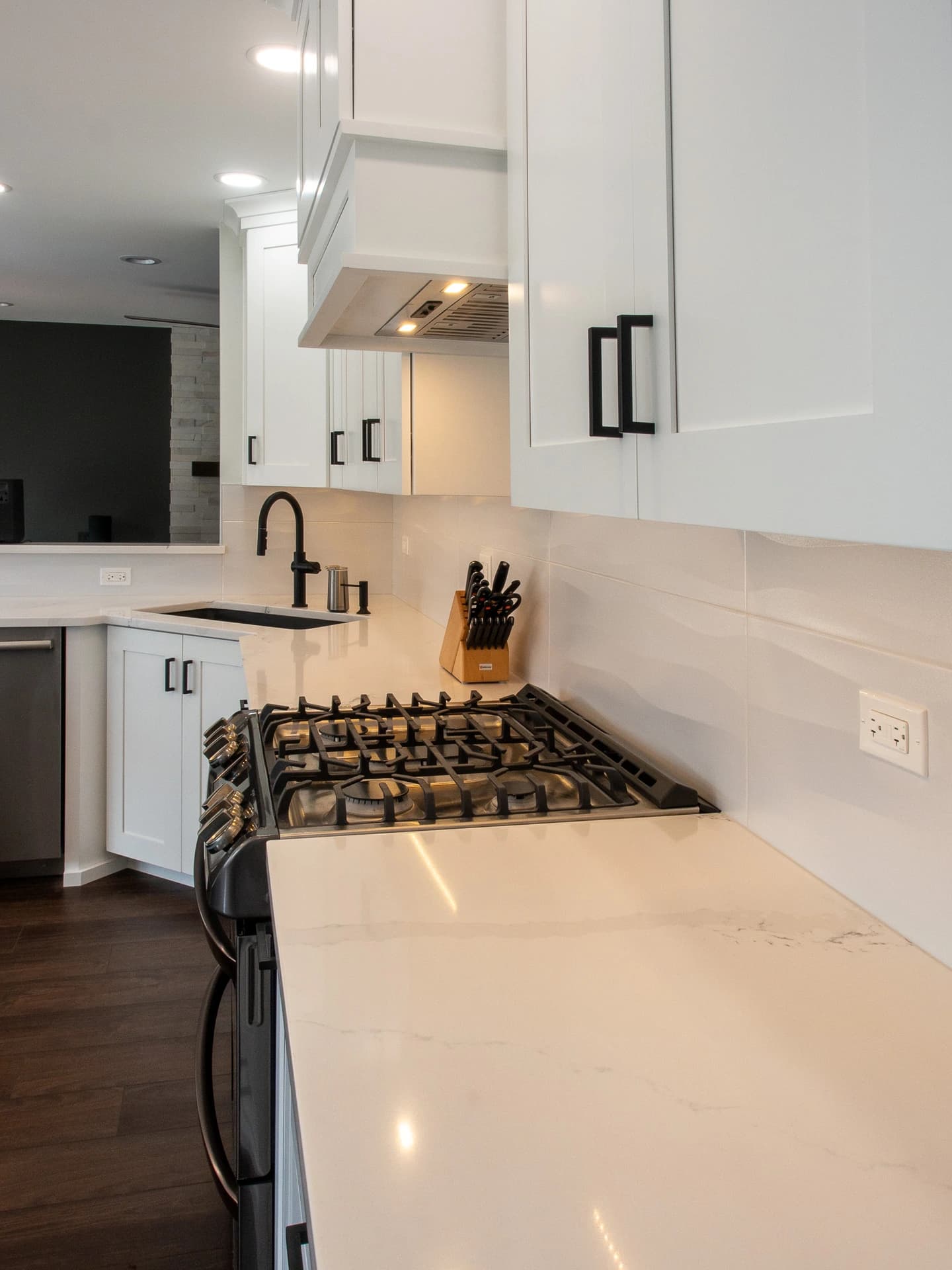 Modern kitchen with white cabinets, granite countertops, and stainless steel appliances.