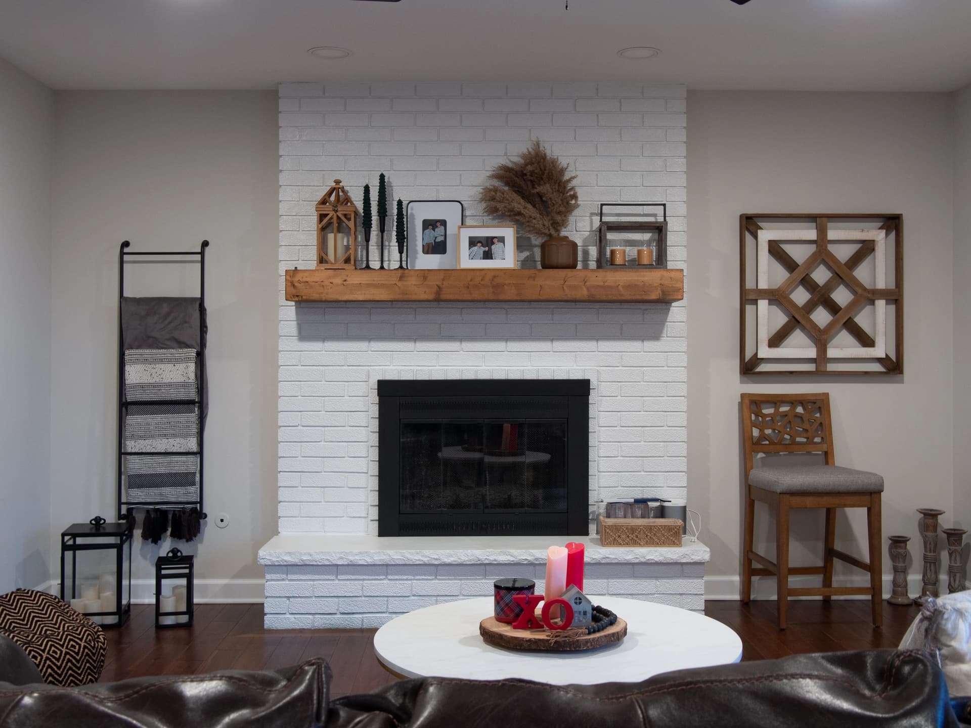 A spacious living room with a white fireplace, modern decor, and warm tones.