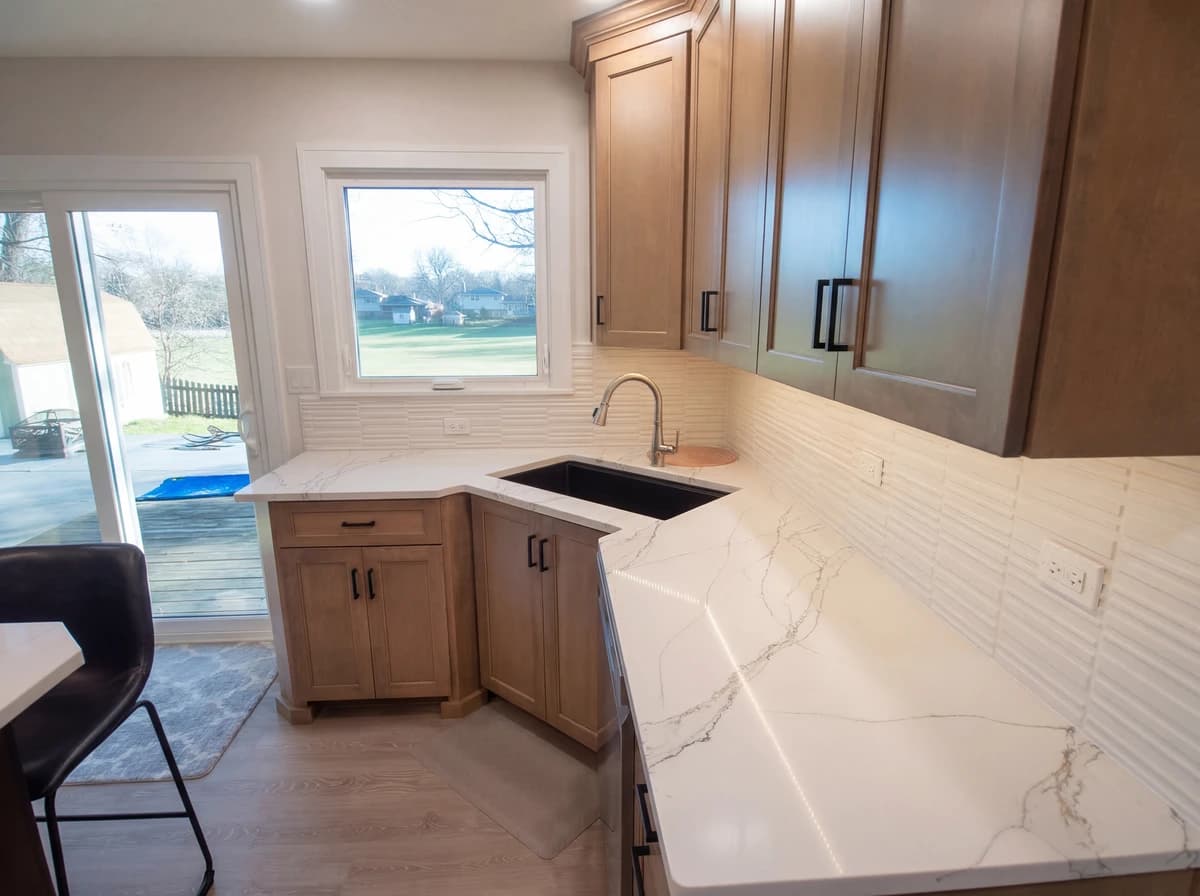 Contemporary kitchen with light wood cabinets, granite countertops, and stainless steel appliances.